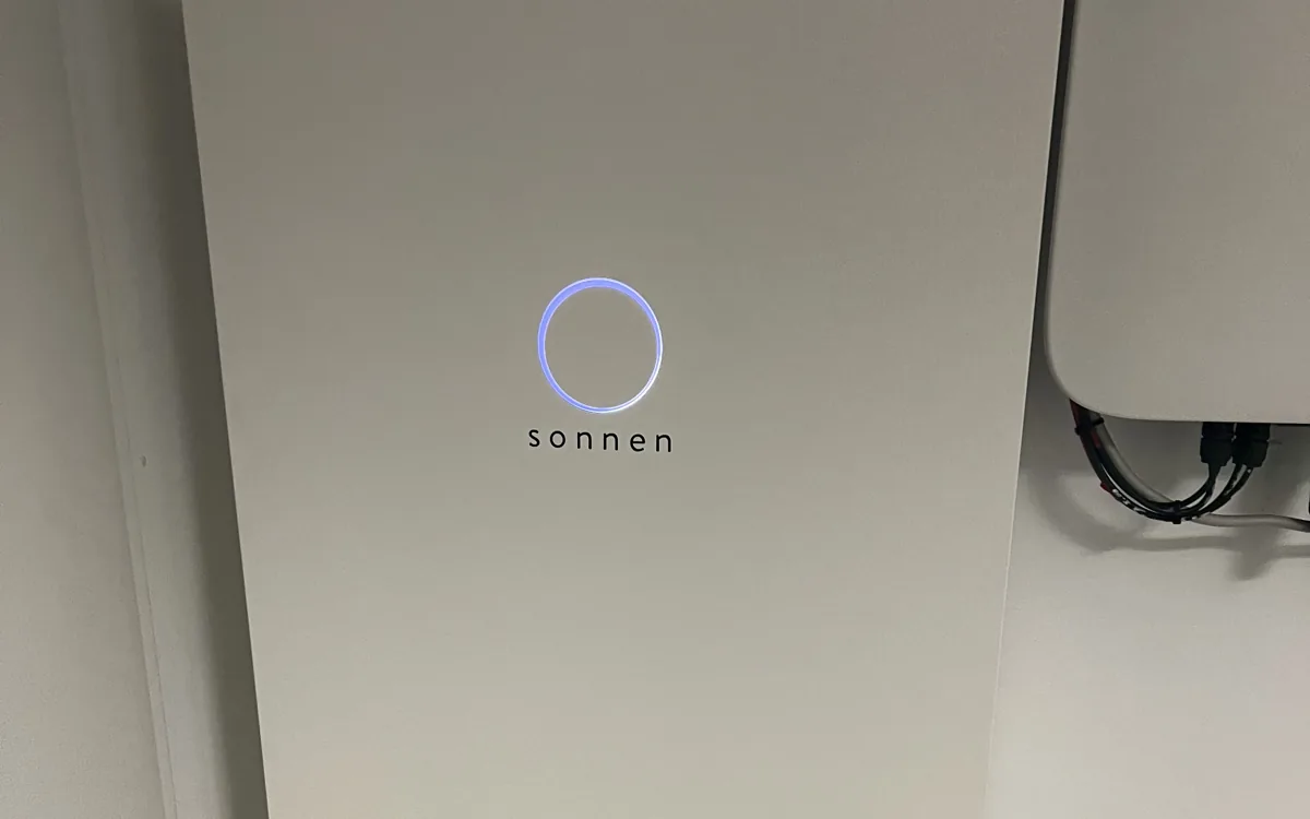 sonnenBatterie mit blau leuchtendem Status-Ring an der Wand
