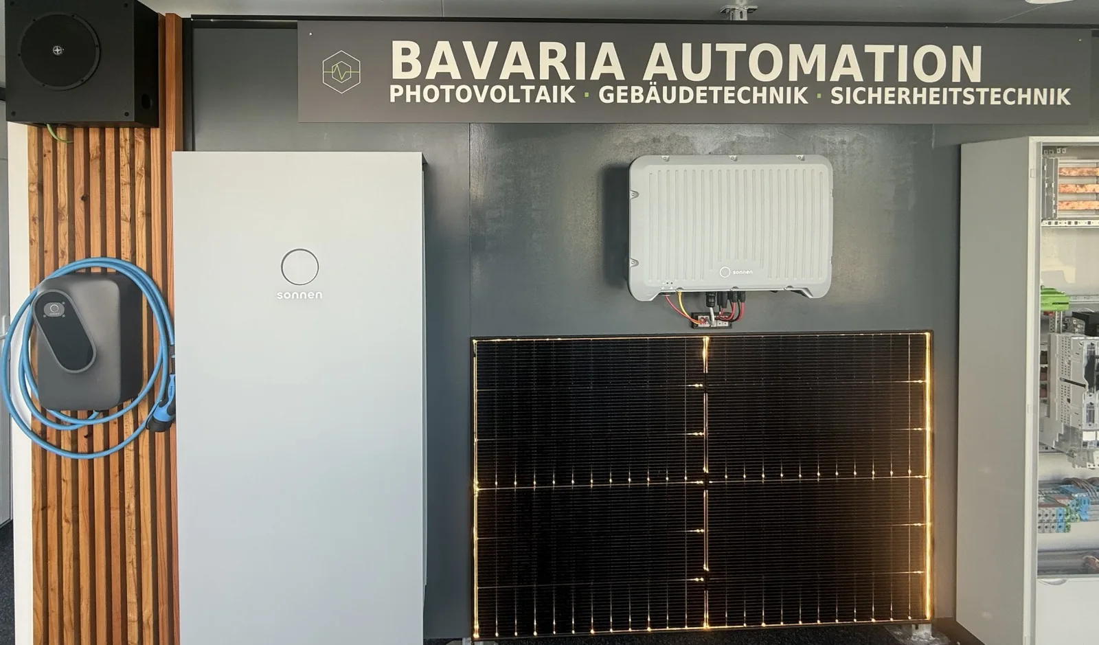 Showroom von Bavaria Automation in Loiching mit sonnenBatterie, Wechselrichter und Solarmodul unter dem Bavaria-Automation-Schriftzug