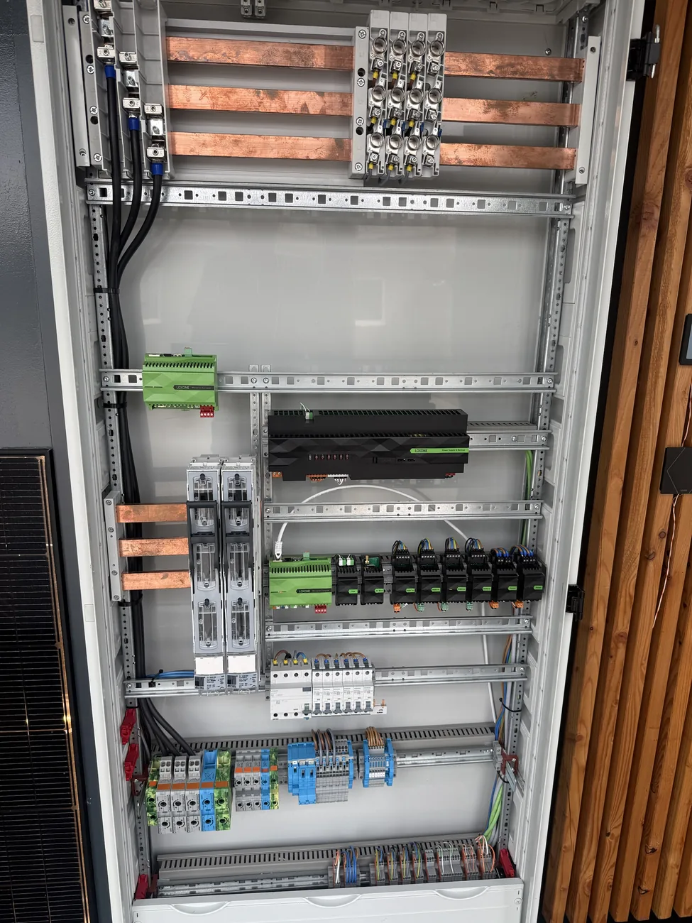 Offener, verglaster Loxone-Meisterschaltschrank im Showroom mit Kupferschienen, Miniserver und Backup