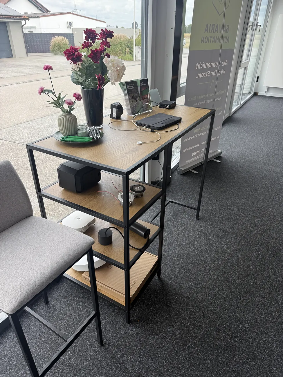 Beratungstisch im Showroom mit Loxone-Smart-Home-Komponenten, Lautsprechern und Broschüren