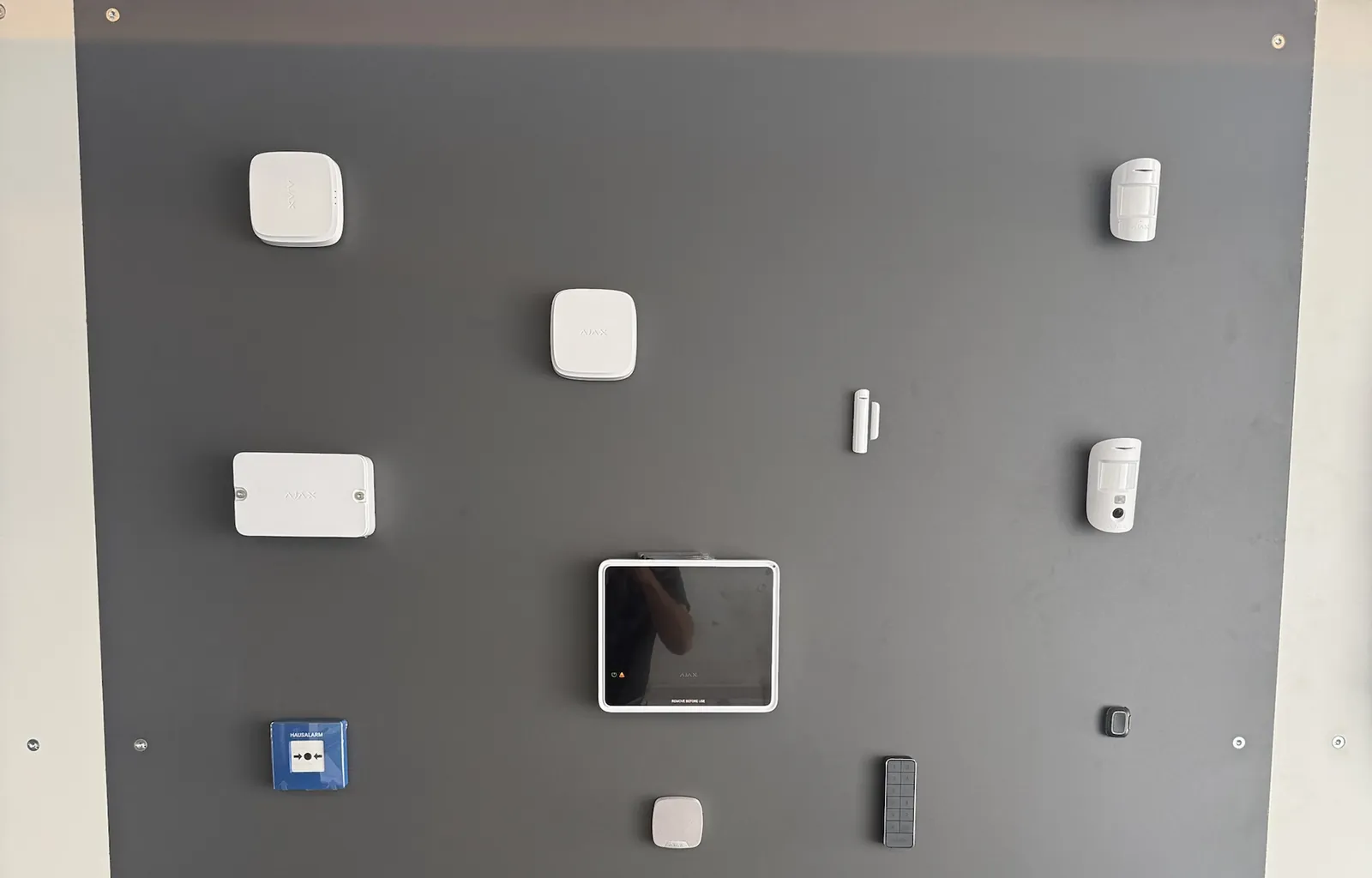 Ajax-Sicherheitswand im Showroom mit Hub, Meldern, Bedienteil und Hausalarm-Taster