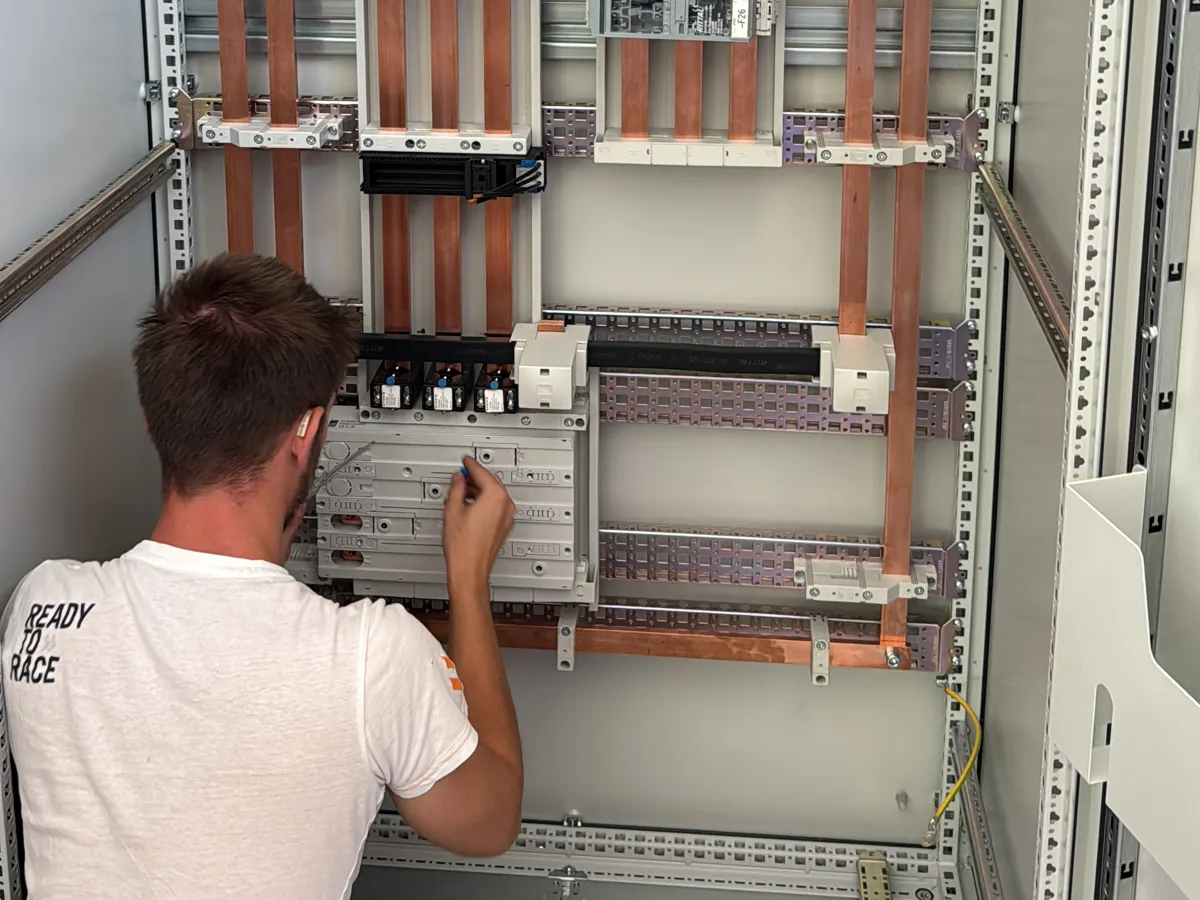 Monteur von Bavaria Automation bei der Arbeit an einer Hauptverteilung mit Kupfer-Sammelschienen